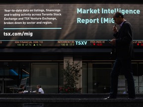 A pedestrian passes in front of the Toronto Stock Exchange in Toronto's financial district.
