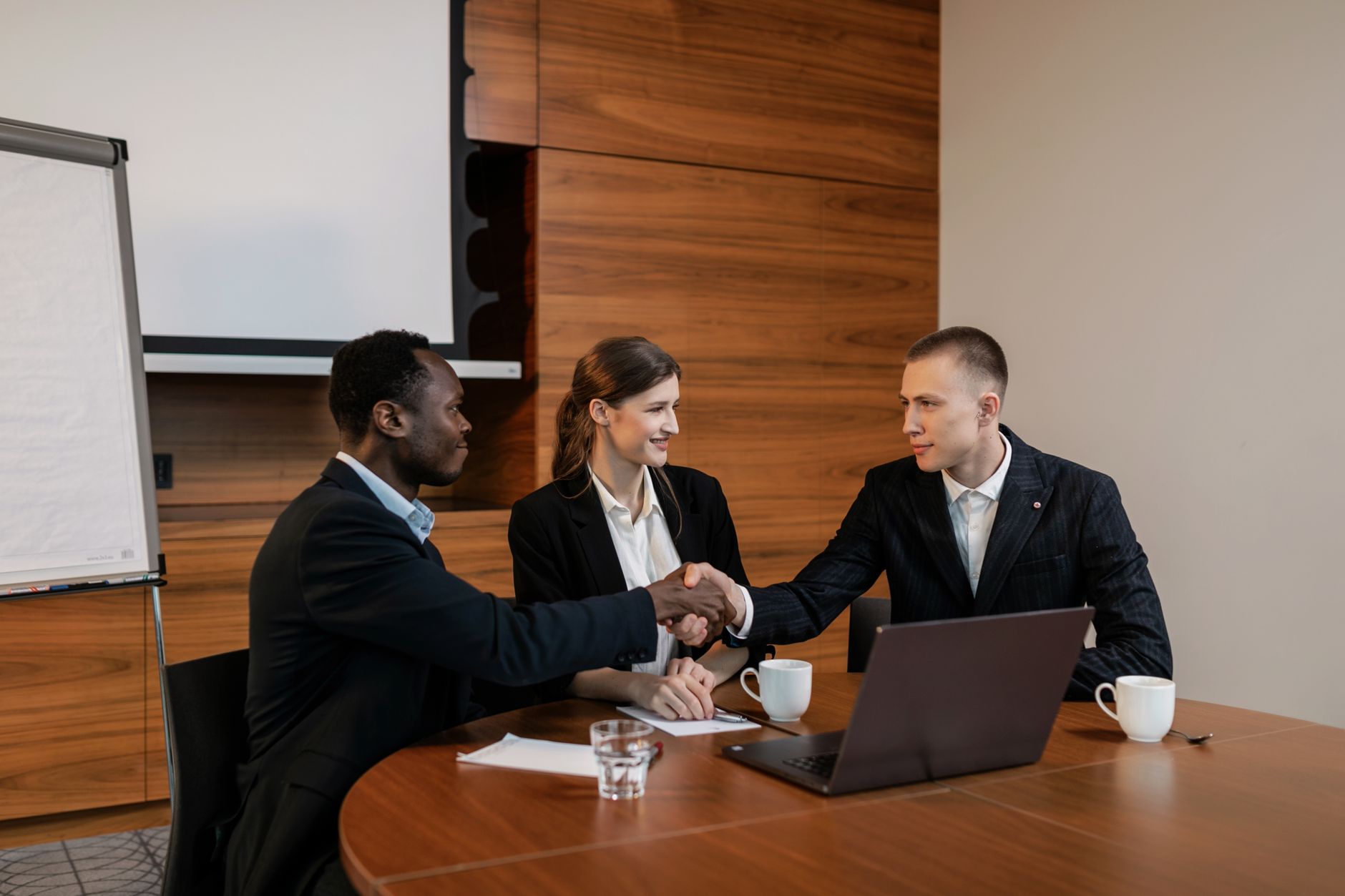 Professionals shaking hands at a business meeting, showcasing teamwork and collaboration. — Dr Valinda Nwadike - Delivering Q