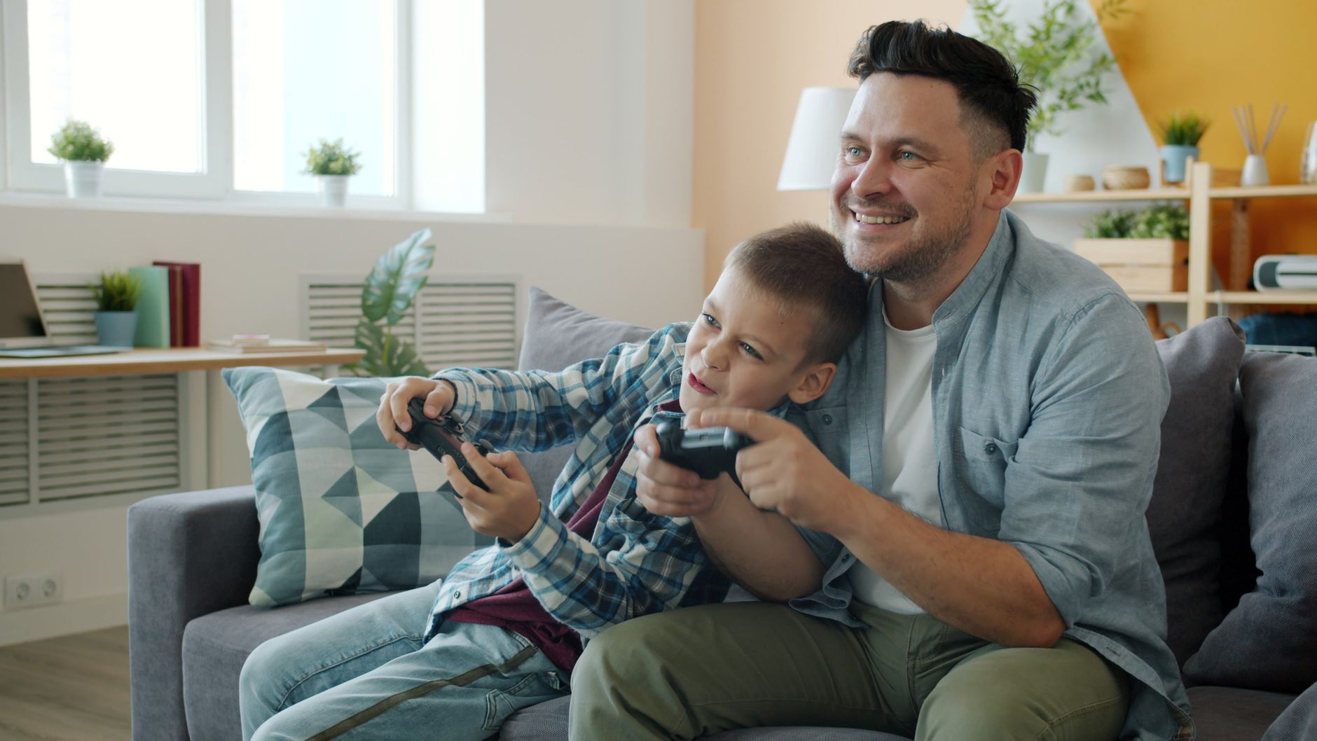 Father and son bonding over video games at home on the sofa. — Experience Real Casino Excitement on a Trusted Direct Baccarat