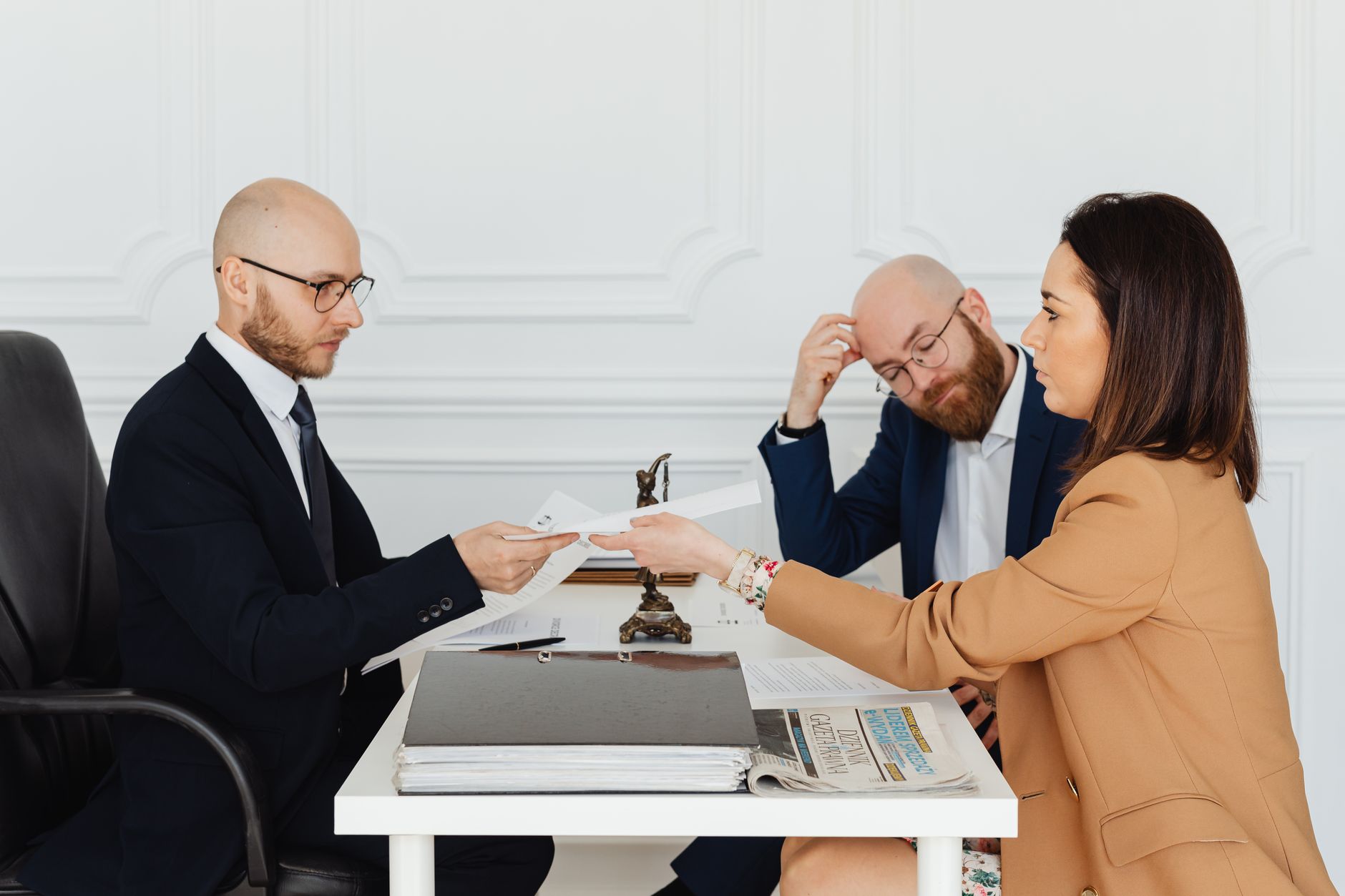 Professional meeting with lawyer and clients discussing documents in a modern office. — Experienced Bail Bondsman in Castle R
