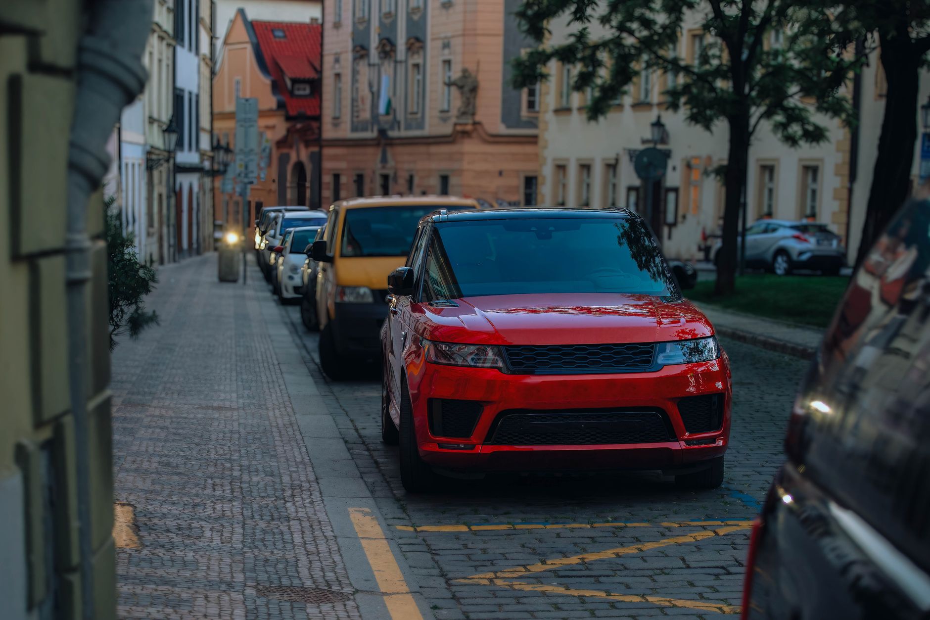 Street view in a city with parked cars, highlighting urban architecture and lifestyle. — How a Car Diagnostic Service Saves Y