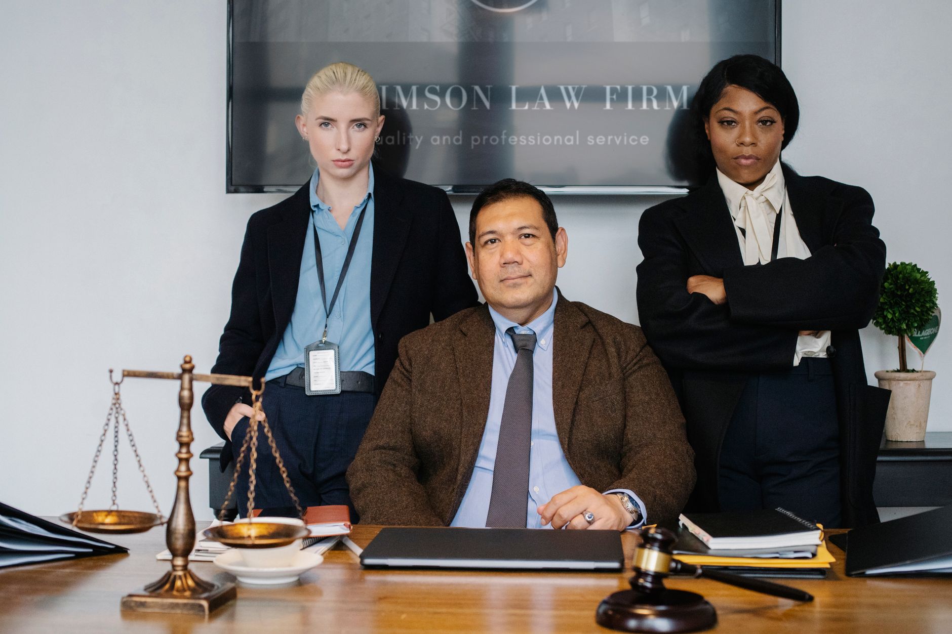 Group of successful multiethnic legislators looking at camera near table with scales of justice and folders — Lawyer Orlando