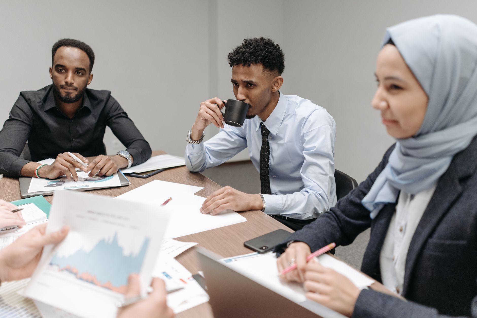 A multicultural team engaged in discussion during an office meeting, highlighting diversity and teamwork. — Revolutionizing R