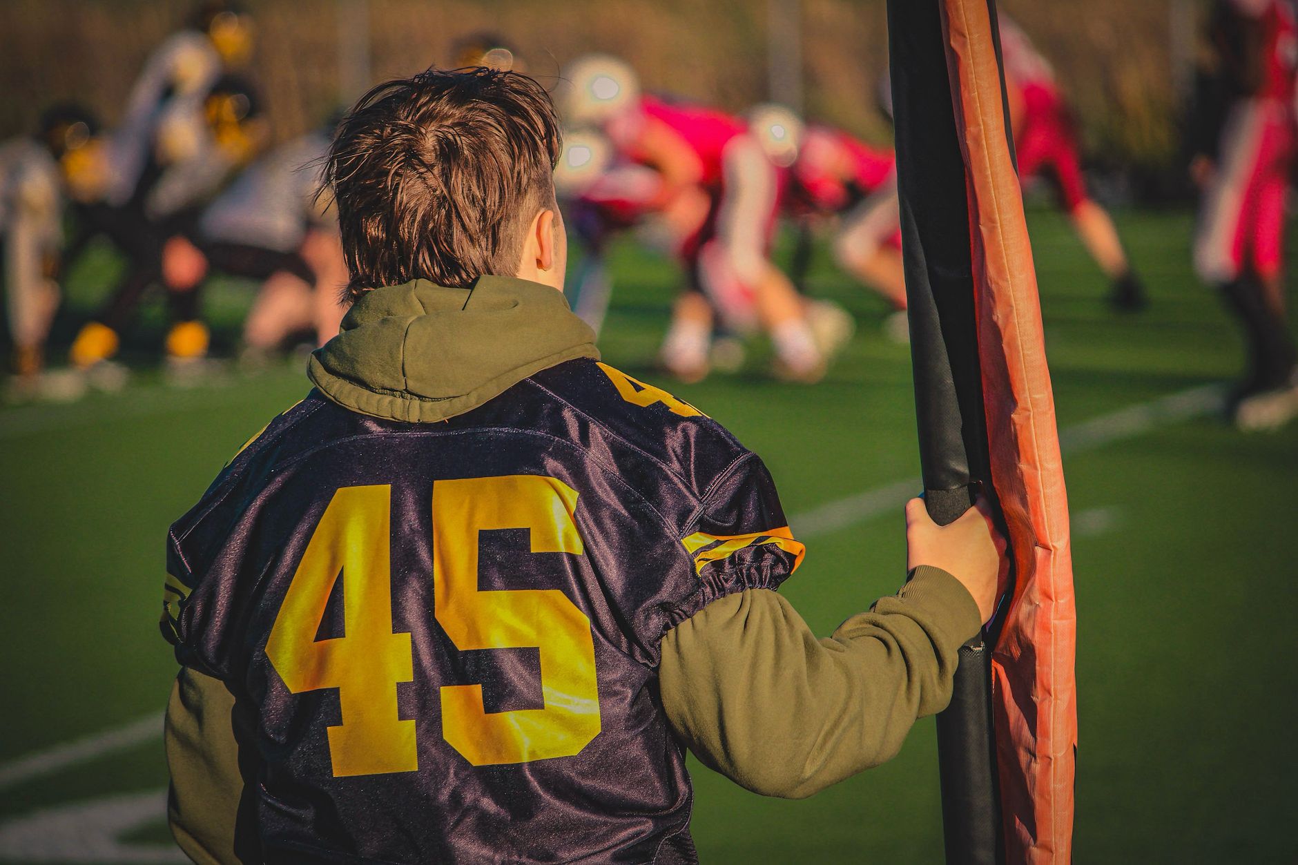 A young football player stands on the sidelines during a team match. — Silent Basketball Built for Consistent Practice and Ev