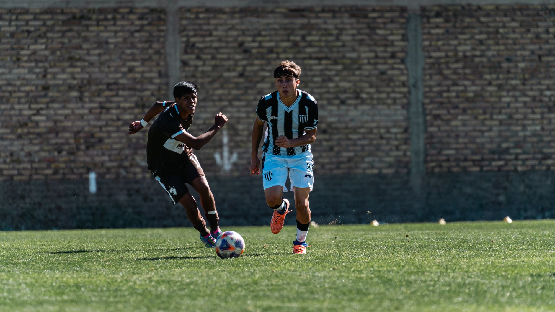 Two players engage in a dynamic soccer game outdoors on green field. — The Competitive Advantage in Modern Sports Media Platf