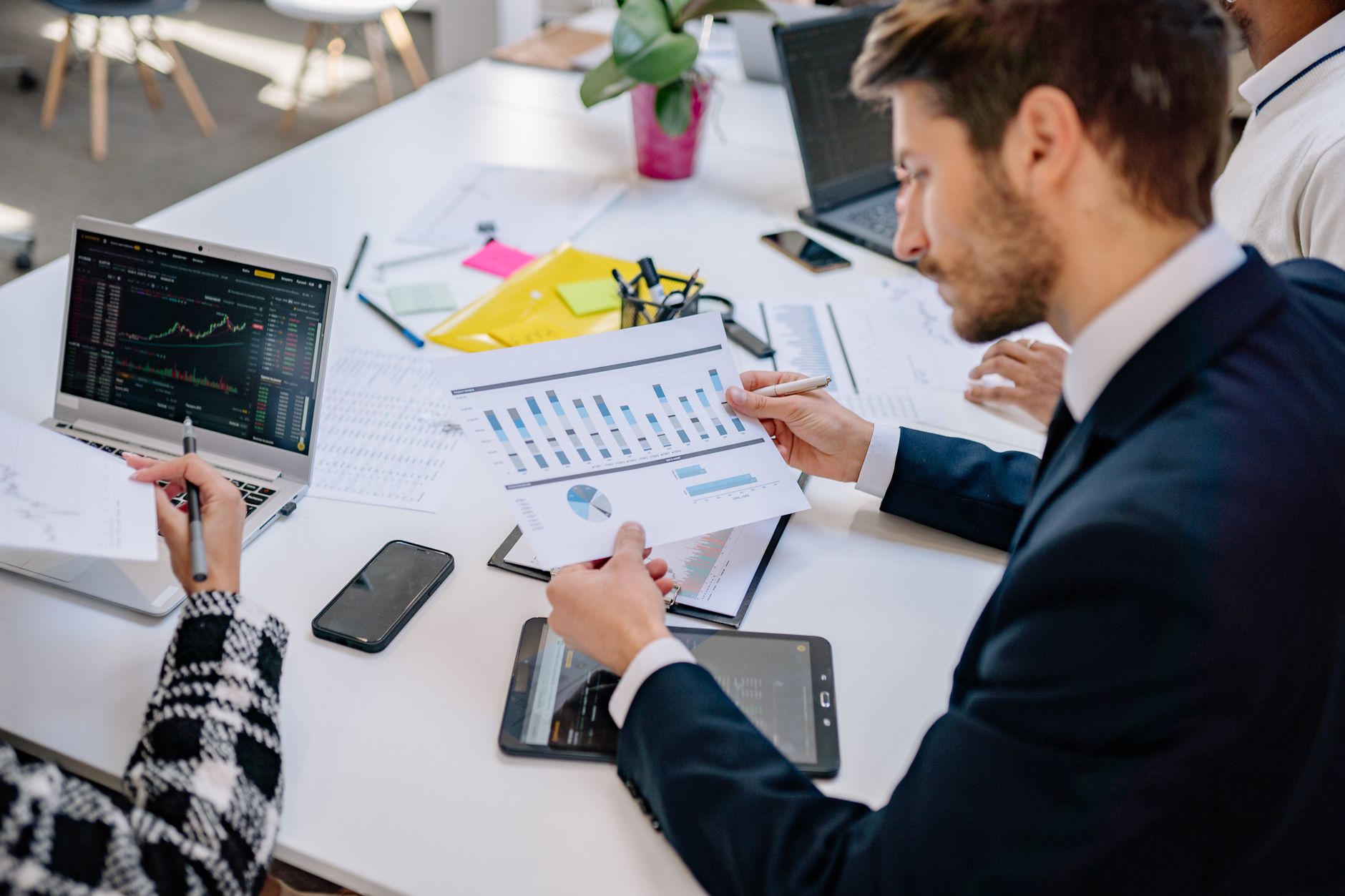 Business team reviewing graphs and data in an office setting. — The Future of Sex Toys: AI-Driven Devices for Personalized Pl