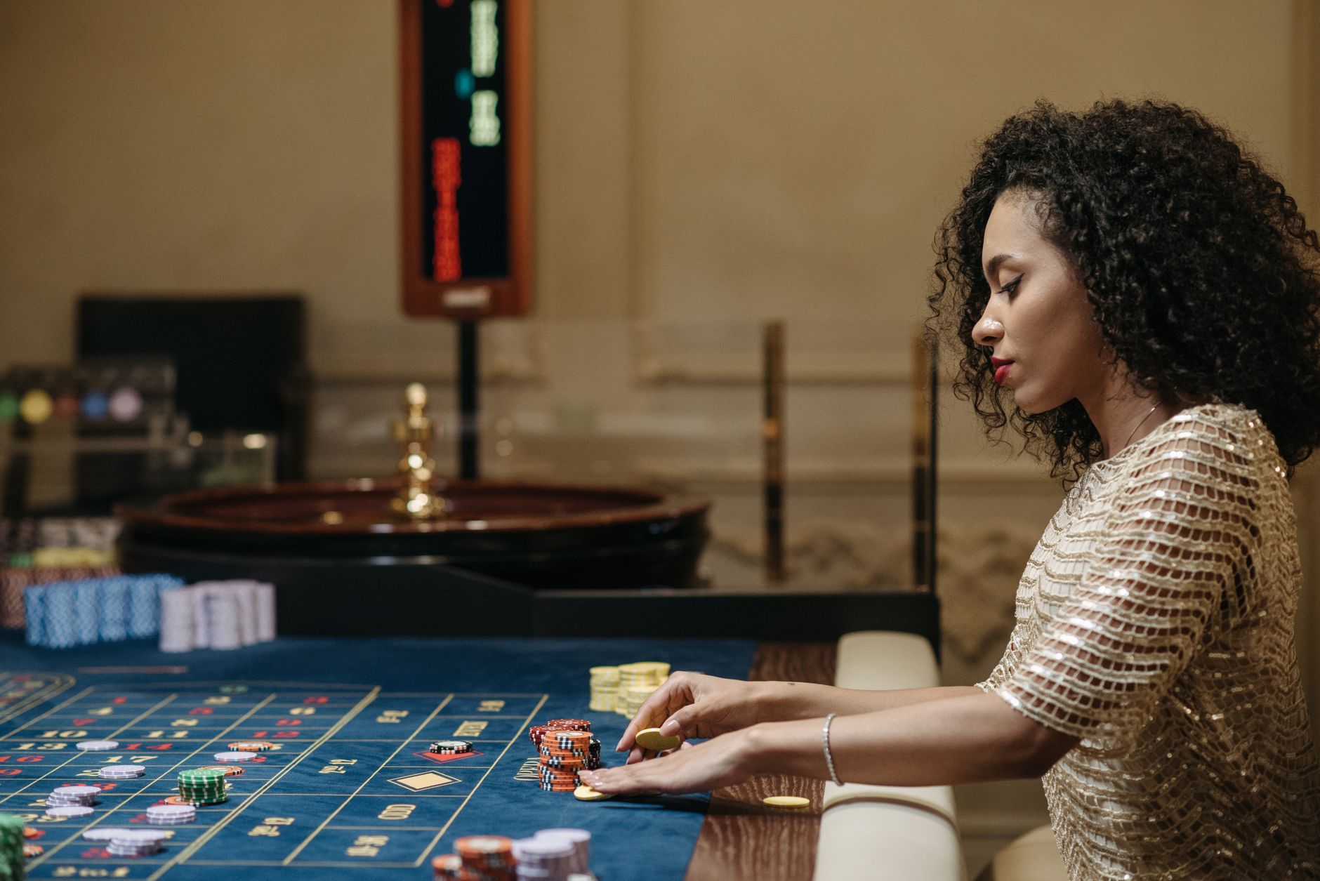 Stylish woman in a casino setting, playing roulette with stacks of chips. — The Most Exciting MPO Gambling Site Designed for