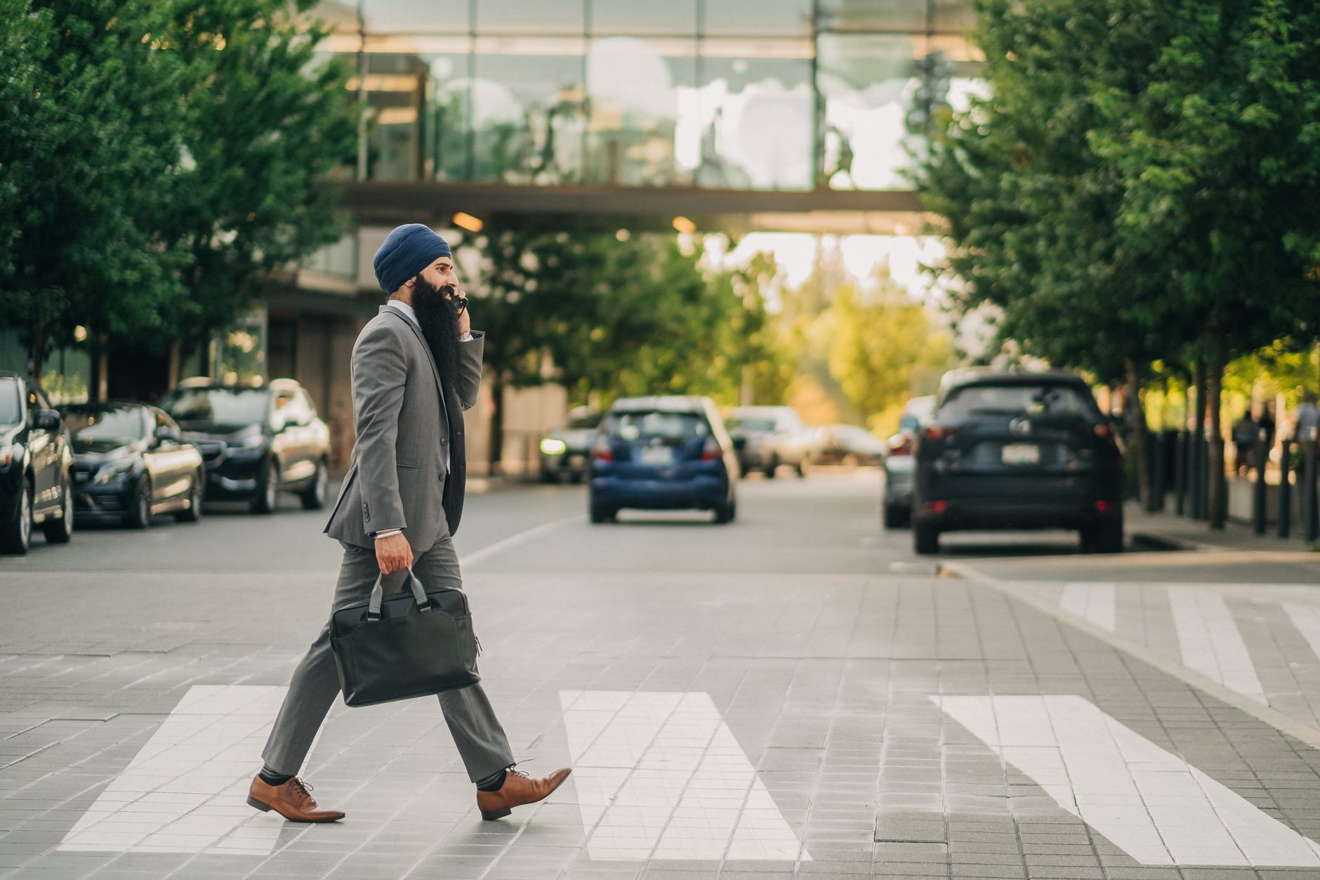 Sikh businessman with a turban crossing a city street on a zebra crossing, carrying a briefcase. — The Role of Bree Montoya i