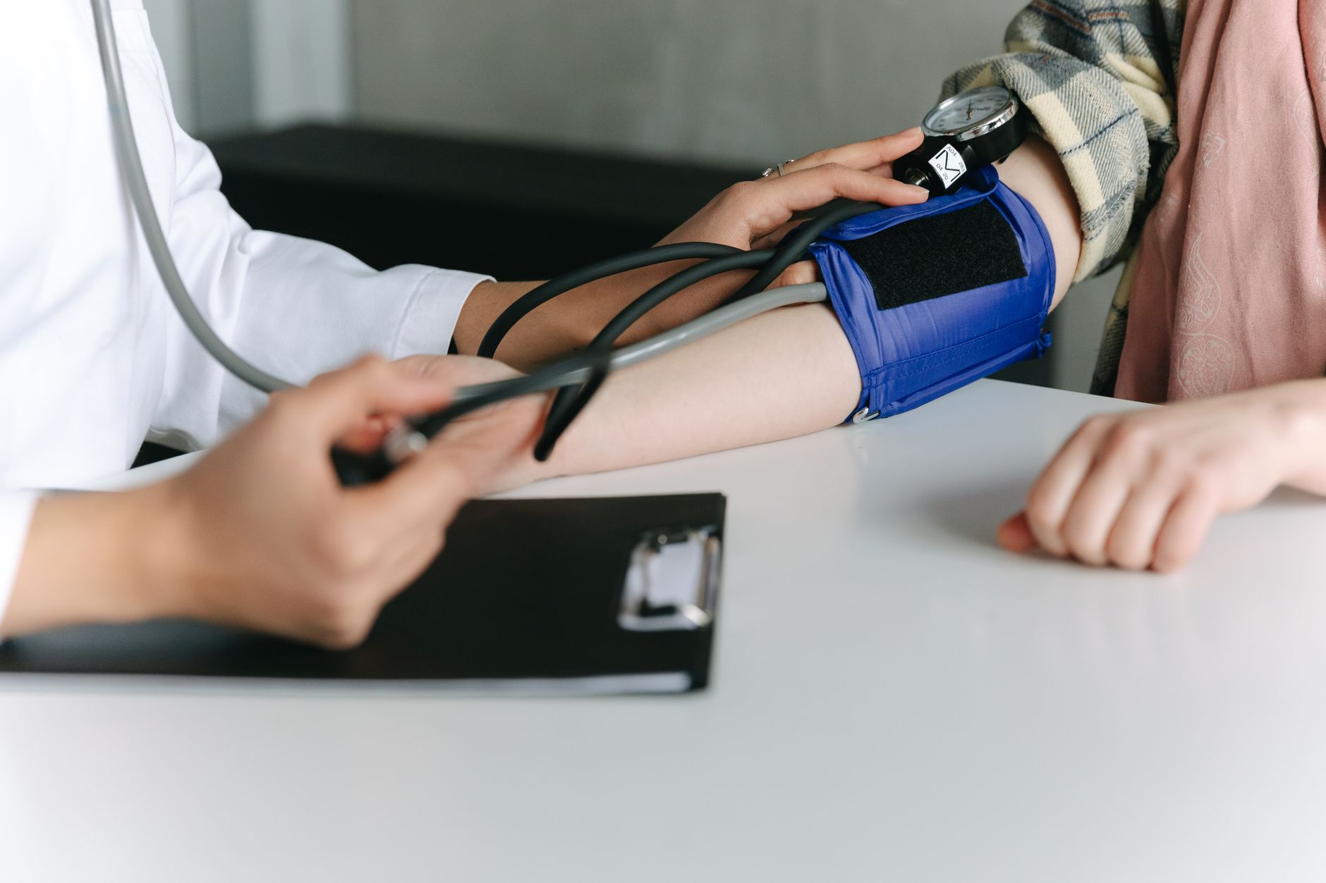 A healthcare worker uses a sphygmomanometer to check a patient's blood pressure in a medical office. — Unlocking a New Level